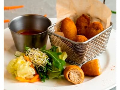 Croquetas caseras de zanahoria y queso de cabra acompañadas de salsa de tomate a las finas hierbas.
