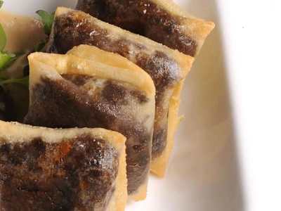 Ravioles crujientes de pasta filo con butifarra de perol con cebolla confitada. (5 uds.)